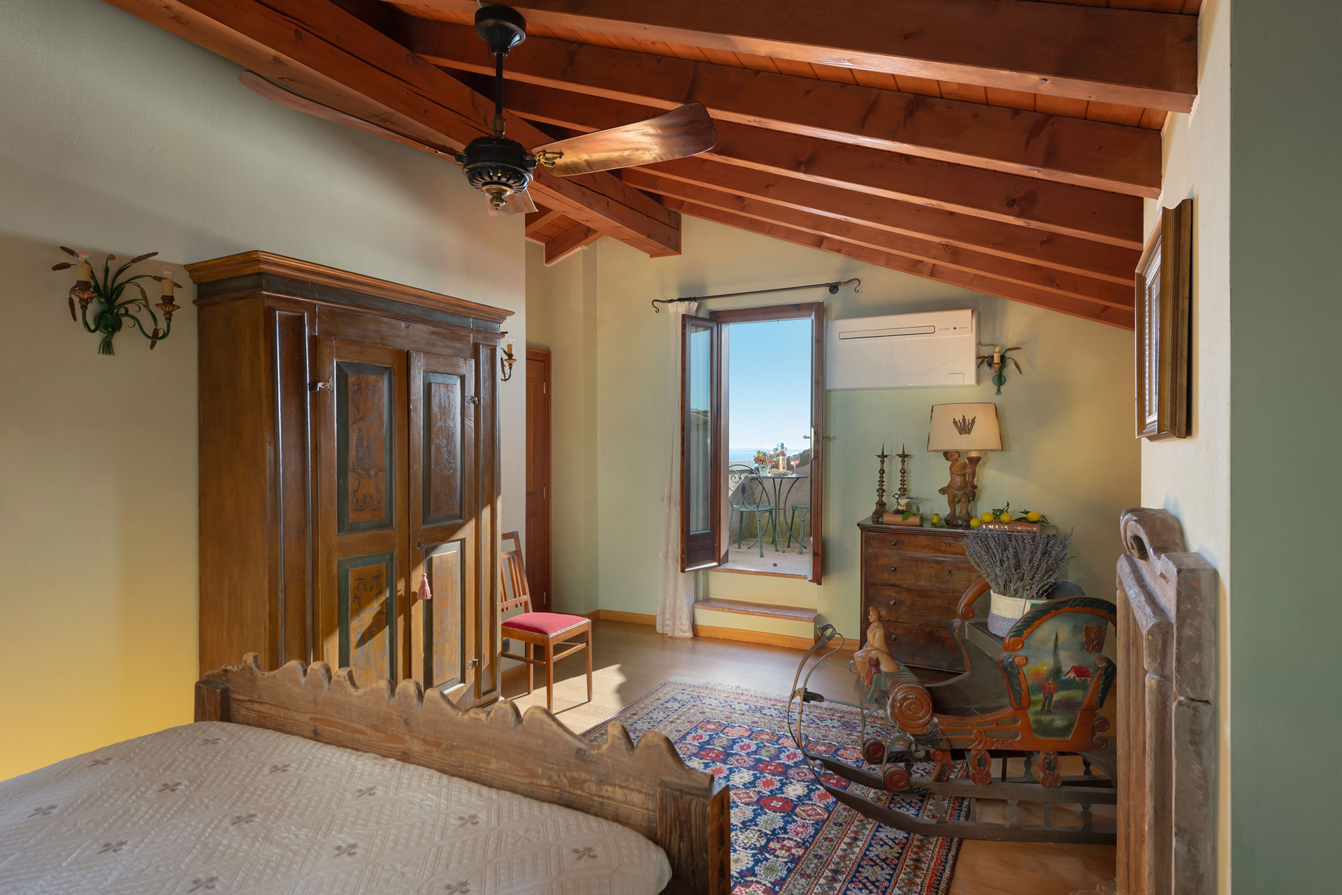 Traditionelles Schlafzimmer mit Holzmöbeln und Zugang zum Balkon